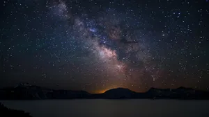 The Milky Over A Lake With Mountains In The Background Wallpaper