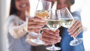 Three Ladies Clinking Glasses Of Alcohol Wallpaper