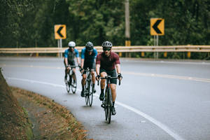 Three Men Winding Road Cycling Wallpaper