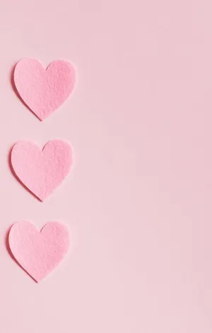 Three Pink Heart Shaped Paper On A Pink Background Wallpaper