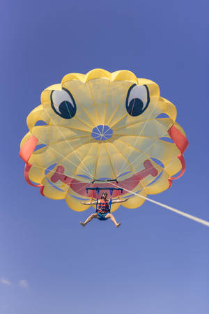 Thrilling Adventure With Smiley Face Parasailing Wallpaper