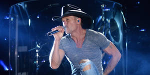 Tim Mcgraw Lively Singing On Stage Wallpaper
