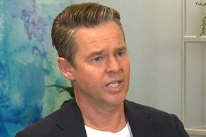 Todd Woodbridge Engaging In An Interview Wallpaper