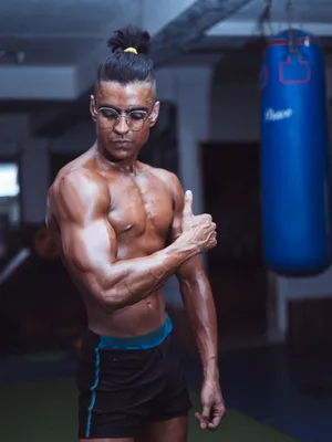 Topless Man With Bun Flex Biceps Wallpaper