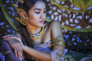 Traditional Thai Woman Adorned In Gold Accessories Wallpaper