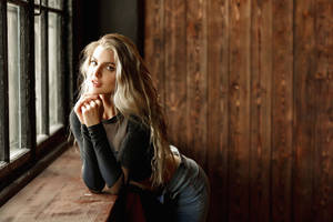 Tranquil Blonde Girl Against Wooden Wall Wallpaper