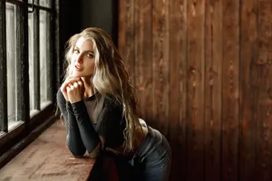 Tranquil Blonde Girl Against Wooden Wall Wallpaper