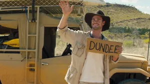 Travelling Chris Holding Dundee Sign Wallpaper