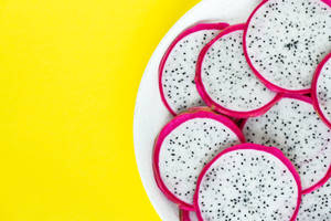 Tropical Feast: Fresh And Juicy Dragonfruit Sliced Open On A Plate. Wallpaper