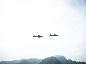 Twin Fighter Planes Soaring Through The Sky Wallpaper