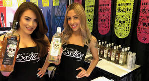 Two Girls Holding Exotico Tequila Bottles Wallpaper