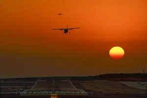 Two Small Airplanes Above Airport Runway Wallpaper