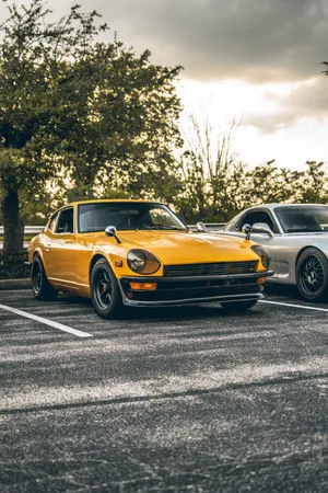 Two Vintage Cars At A Parking Lot Wallpaper