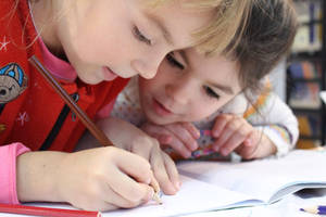 Two Young Children Engaging In Interactive Learning Wallpaper