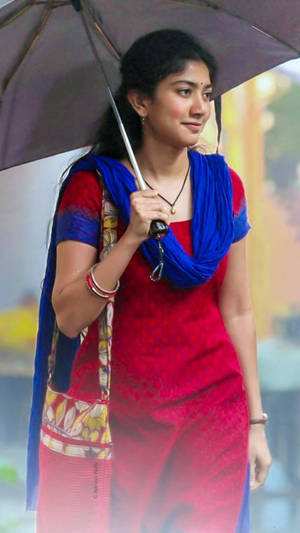 Versatile Actress Sai Pallavi Bracing The Rain With An Umbrella Wallpaper