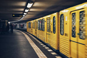 Vibrant Yellow Subway Train In Motion Wallpaper