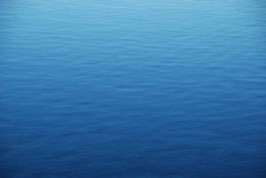 View From Above Of The Calm Blue Ocean Water Wallpaper