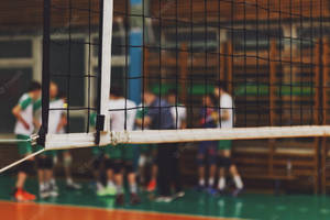 Volleyball Net In A Gym With People Playing Volleyball Wallpaper