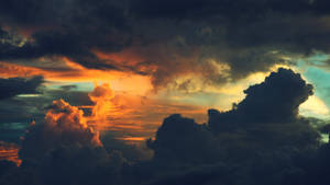 Watching The Dramatic Sun Set In The Clouds Wallpaper