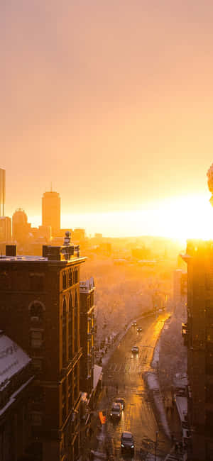 Watching The Orange Glow Of The Sunset Over The City Skyline Wallpaper