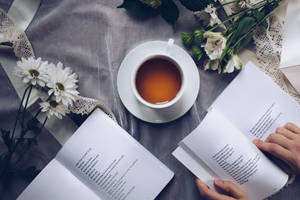 White Ceramic Teacup With Saucer Near Two Books Wallpaper