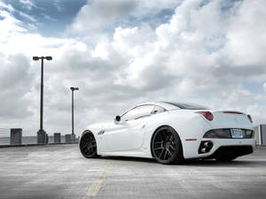 White Ferrari Under Fluffy Clouds Wallpaper