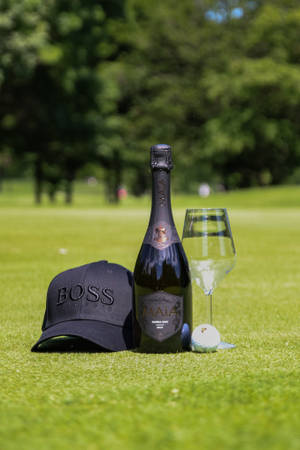 Wine Bottle Glass And Cap On Golf Course Wallpaper