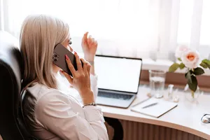 Woman Conducting Business Call At Home Office Wallpaper