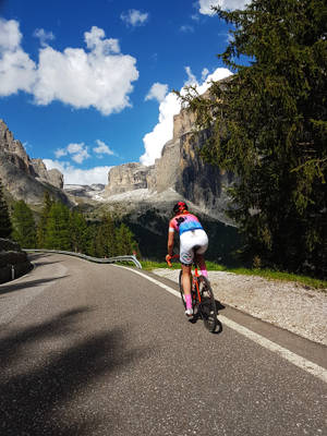 Woman Cycling Alps Road Wallpaper