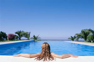 Woman Enjoying Solitude In A Swimming Pool Wallpaper