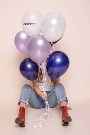 Woman Holding Glossy Balloons Wallpaper