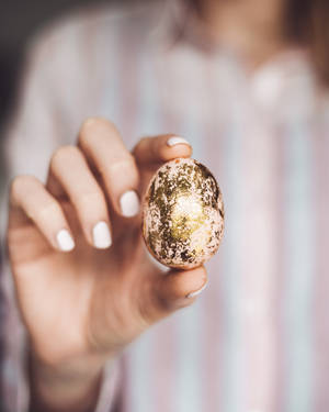 Woman Holding Gold Easter Egg Wallpaper