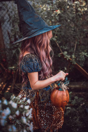 Woman Holding Spooky Pumpkin Basket Wallpaper