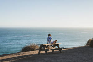 Woman On Malibu Beach Picnic Table Wallpaper