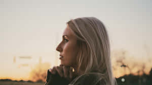 Woman Praying Headshot During Sunset Wallpaper