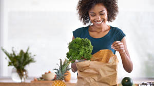 Woman Unpacking Grocery Items Wallpaper