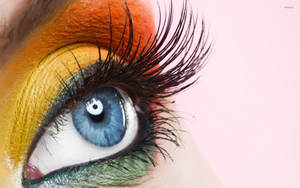 Woman With Orange And Yellow Eye Makeup Wallpaper