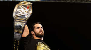 Wwe Wrestler Seth Rollins Raising His Belt Wallpaper