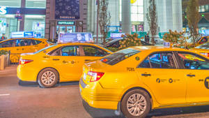 Yellow Taxi Cab In Front Of Mall Wallpaper