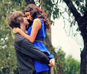 Young Couple In Love Embracing In An Intimate Moment Wallpaper