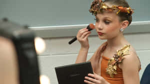 Young Dancer Applying Makeup Backstage Wallpaper