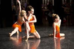 Young Dancers Orange Fringe Costumes Wallpaper