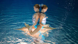 Young Girls Competing In Artistic Swimming Wallpaper