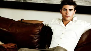 Zac Efron In Brown Couch Wallpaper