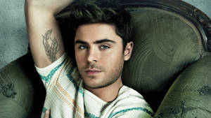 Zac Efron In Green Couch Wallpaper