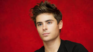Zac Efron In Red Backdrop Wallpaper